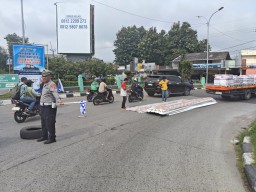 Aipda mahfendra Bhabinkamtibmas Polsek Kedawung Polres Ciko Bantu evakuasi Material yang Jatuh Saat Ngatur Arus Mudik