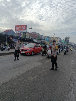 Anggota Polsek Mundu Bantu Warga Menyebrang Saat Lalu Lintas Padat di Depan Pasar Mundu